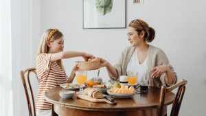 A warm family breakfast with mother and daughter sharing a meal in a cozy dining area.